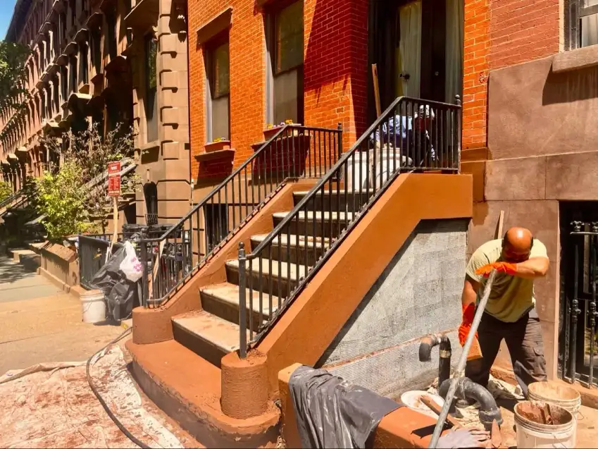 Mixing at the base of the stoop — cheek walls coated, treads next