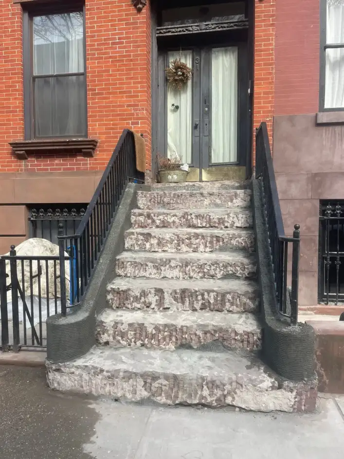 The stoop at 31 South Oxford Street before restoration — worn, patchy, and spalling